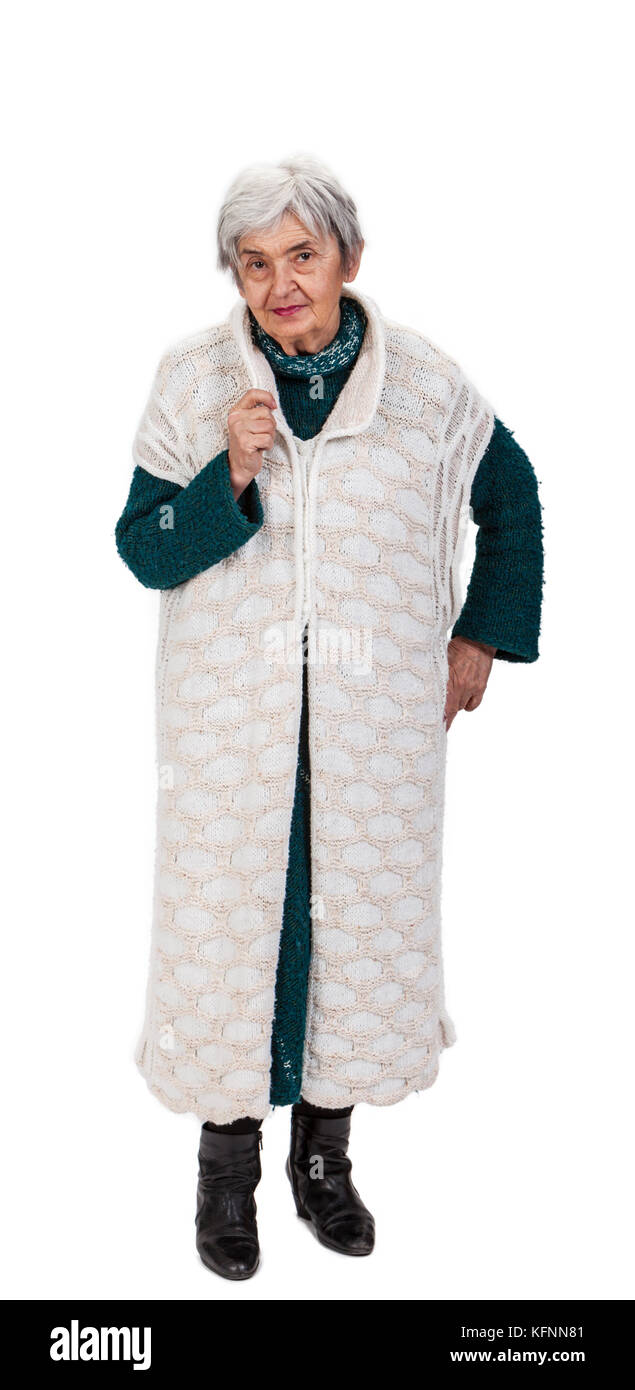Une jolie vieille dame en vêtements tricotés debout sur un fond blanc. Banque D'Images