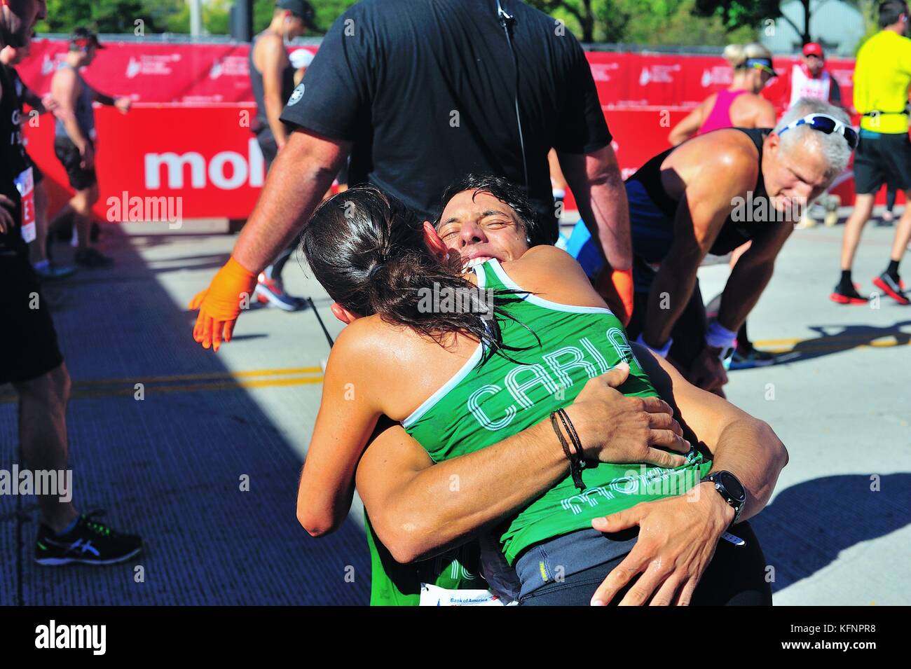 Juste après avoir traversé la ligne d'arrivée à la 2017 Marathon de Chicago, un couple embrasser après s'engager à être mariés. Banque D'Images