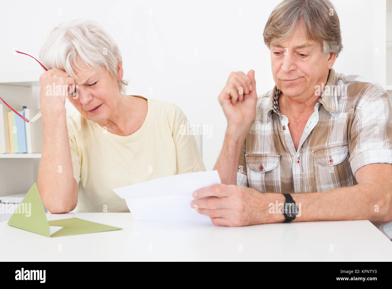 Senior couple ont été déçus lors de la lecture de lettre sur la table Banque D'Images