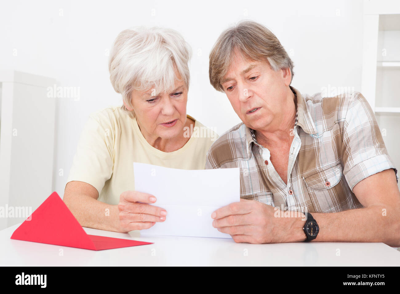 Senior couple ont été déçus lors de la lecture de lettre sur la table Banque D'Images
