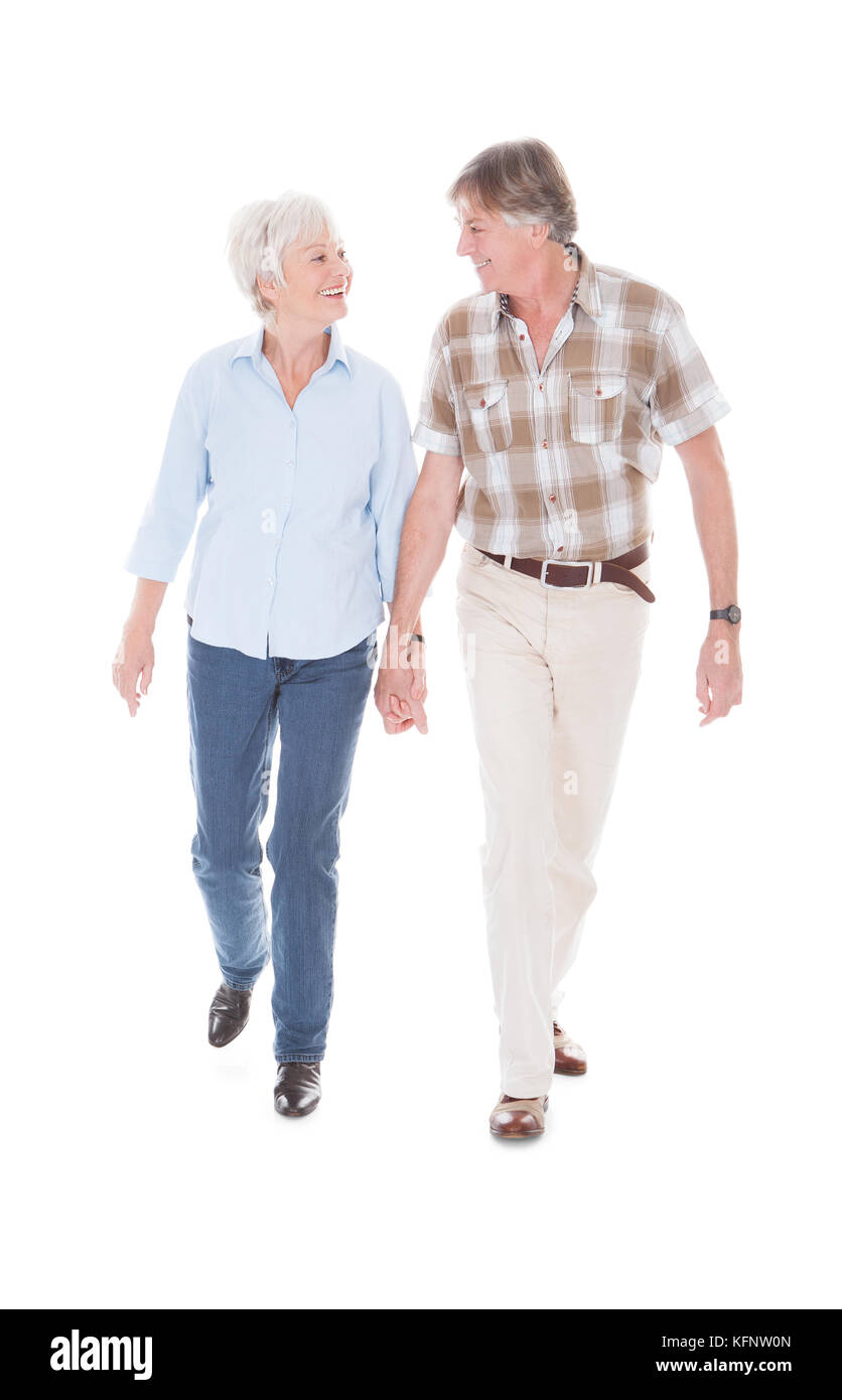 Happy Senior Couple Holding Hand et marcher sur fond blanc Banque D'Images