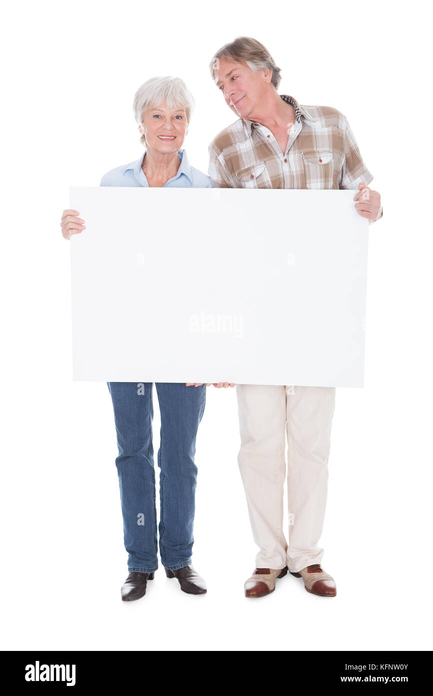 Quel beau Couple Senior détenant ensemble un tableau blanc en blanc sur fond blanc Banque D'Images Quel beau Couple Senior détenant ensemble un tableau blanc en blanc sur fond blanc Banque D'Images