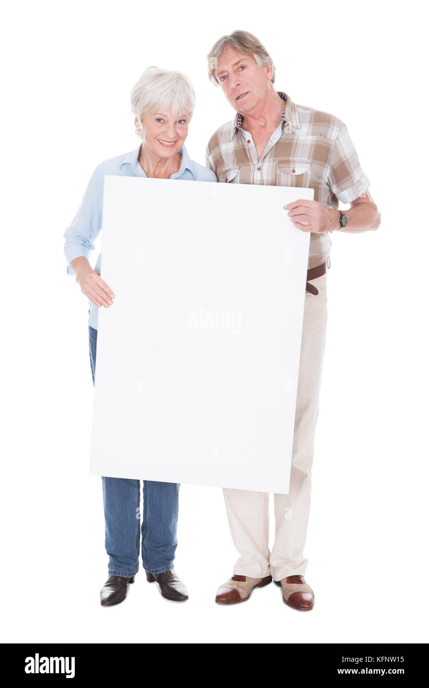 Quel beau Couple Senior détenant ensemble un tableau blanc en blanc sur fond blanc Banque D'Images Quel beau Couple Senior détenant ensemble un tableau blanc en blanc sur fond blanc Banque D'Images
