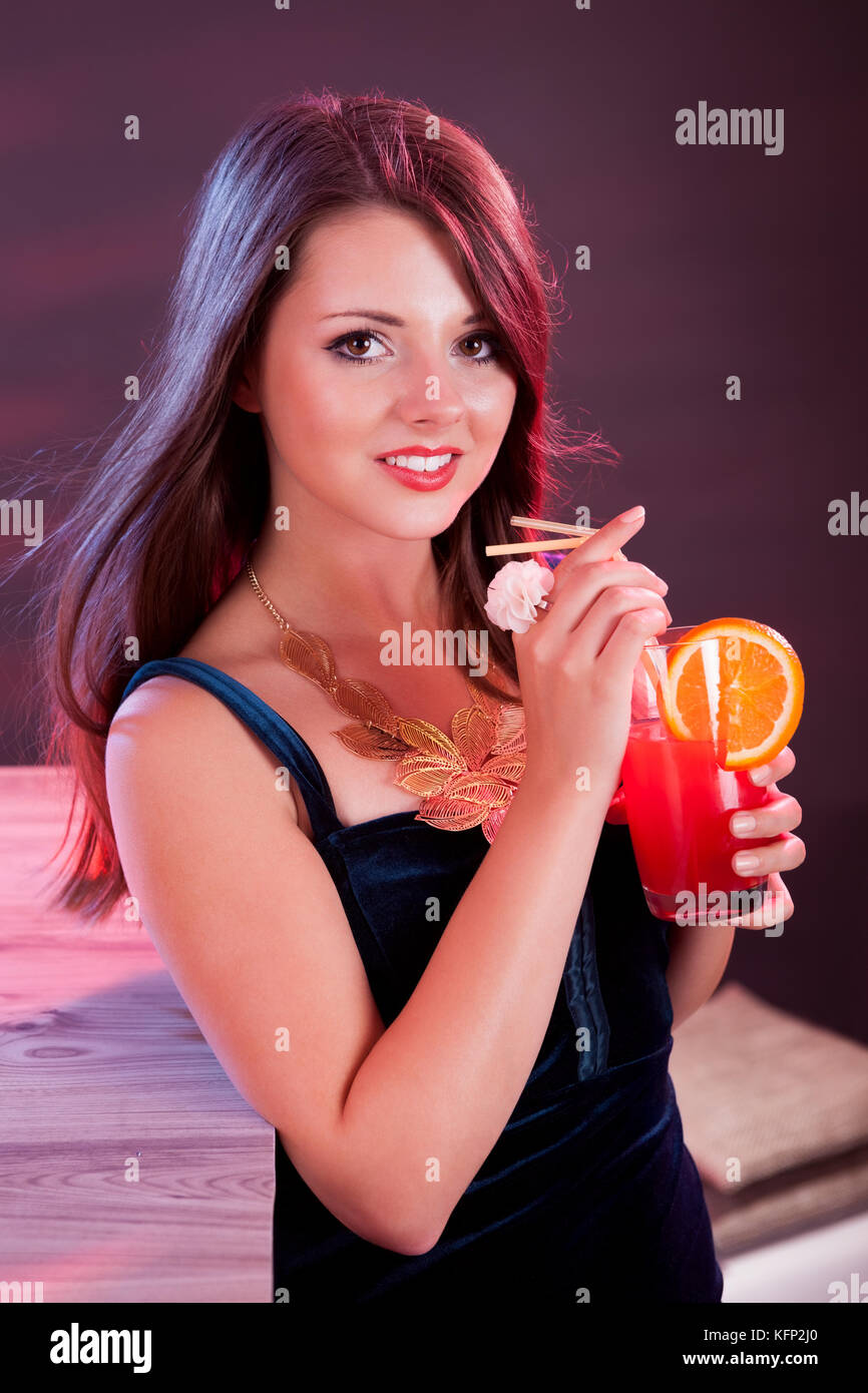 Belle femme glamour dans une robe du soir la tenue d'un cocktail dans la  main tout en se tenant au bar dans une boîte de nuit Photo Stock - Alamy
