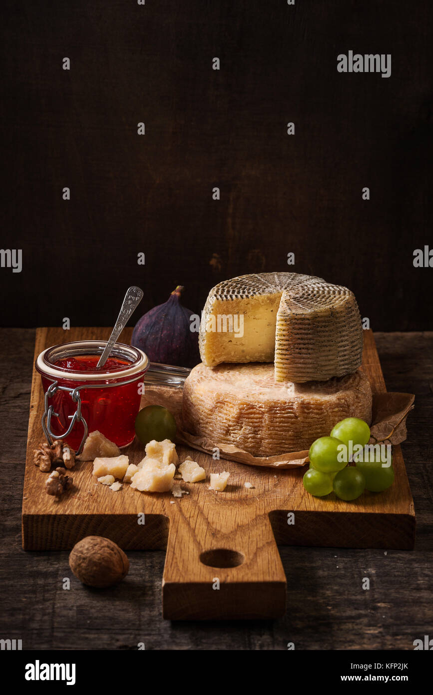 La vie encore sombre avec un plateau de fromages, fruits et vin Banque D'Images