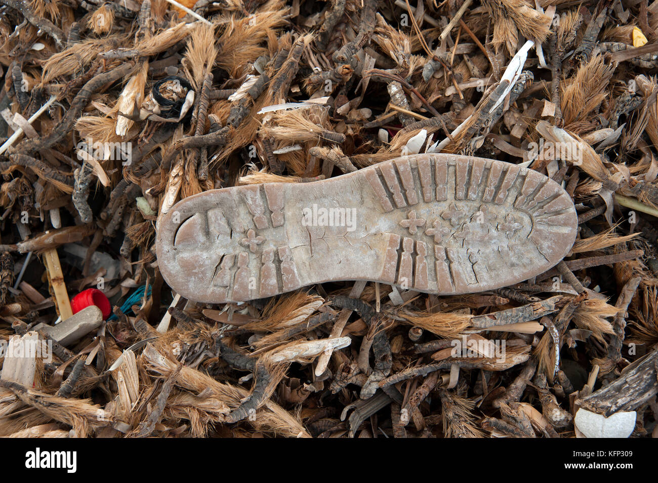 Unique en plastique d'un soufflet en caoutchouc est échoué sur une plage de galets sur l'île des Baléares de Minorque espagne Banque D'Images