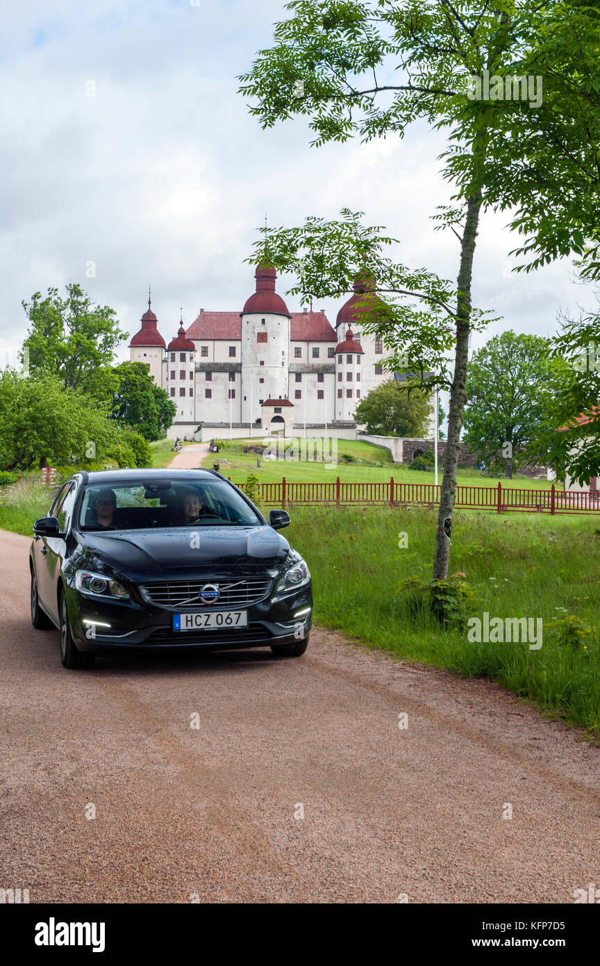 Une Volvo V60 D4 la conduite en face de Läckö Slott, un château médiéval sur l'Île Kållandsö, ouest de la Suède. Banque D'Images