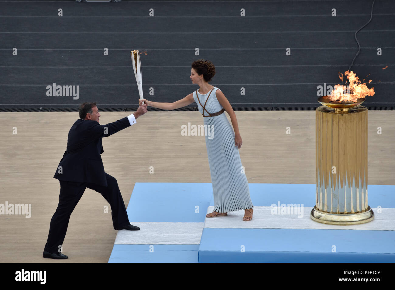 Athènes, Grèce, 31 octobre 2017. La Grande prêtresse Katerina Lehou (à droite) remet la flamme olympique au président du Comité Olympique hellénique Spyros Capralos (à gauche) lors de la cérémonie de remise de la flamme olympique pour les Jeux olympiques d'hiver de PyeongChang 2018 au stade panathénaïque d'Athènes, en Grèce. Crédit : Nicolas Koutsokostas/Alamy Live News. Banque D'Images