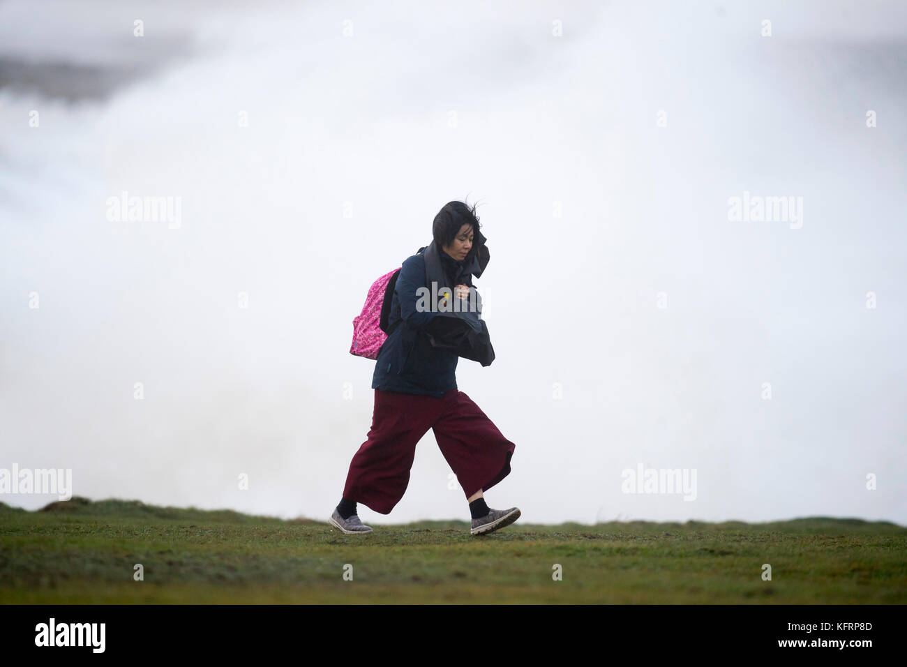 Une femme entre dans le vent de tempête au cours de Brian à Porthcawl, Galles du Sud. Le Met Office ont émis un avertissement de vent météo jaune et ont mis en garde Banque D'Images