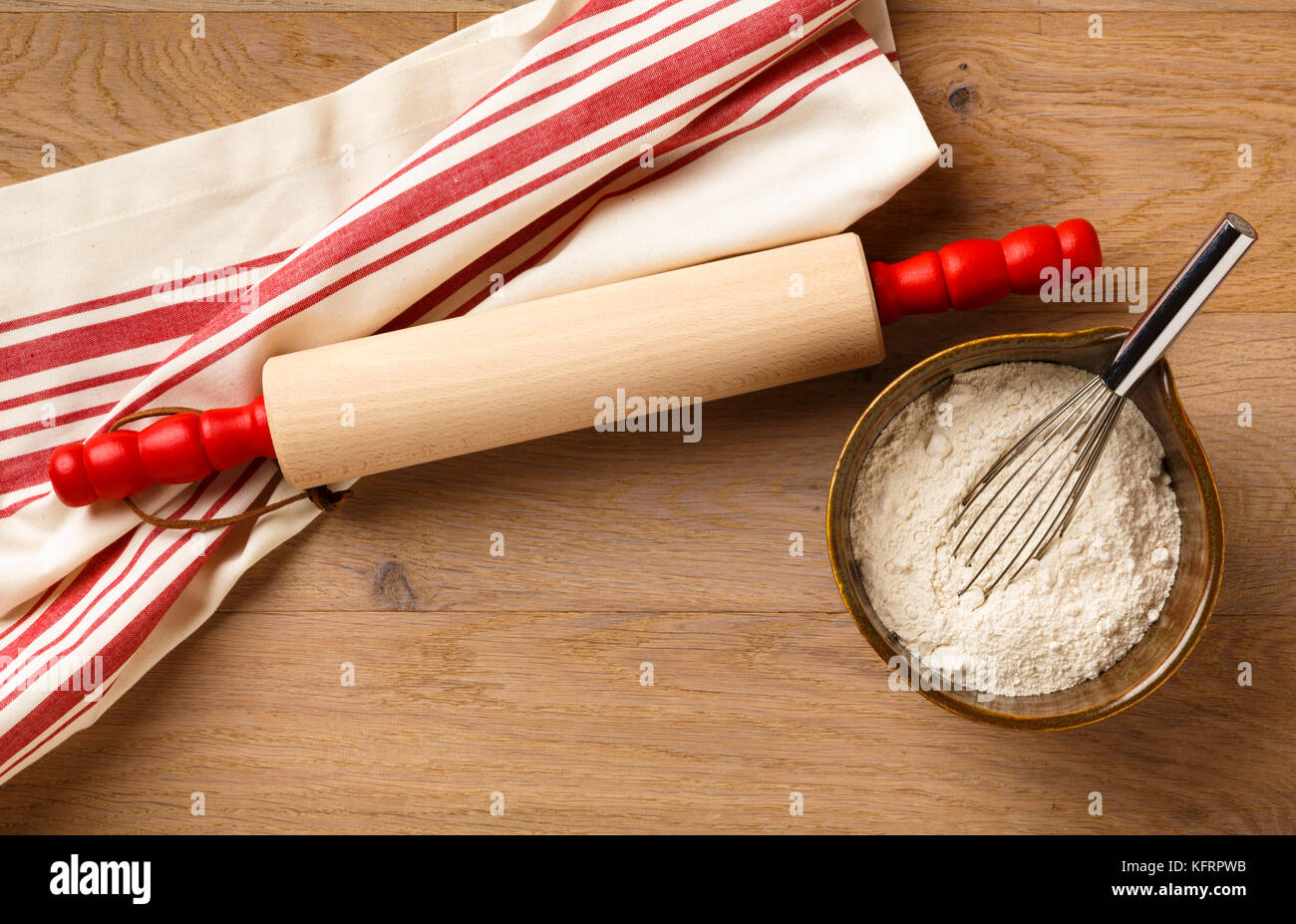 Table de cuisine avec ustensiles de cuisine comptoir comptoir rouleau à pâtisserie en bois et coton torchon torchon, et ingrédients dans un bol de farine blanche Banque D'Images