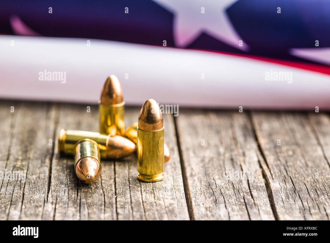 Balle de pistolet et usa drapeau sur la vieille table en bois. Banque D'Images