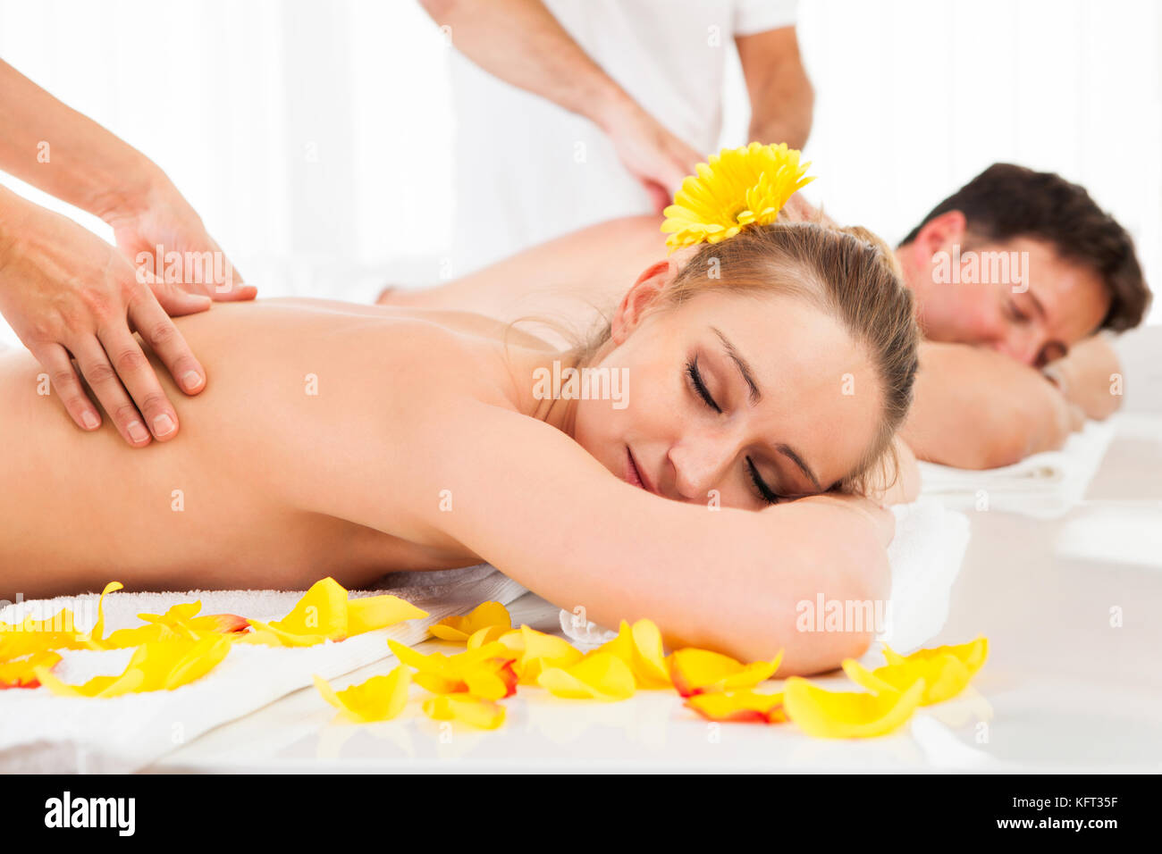 Beau couple couché côte à côte dans un spa offrant le luxe d'un massage en profondeur des tissus ensemble Banque D'Images