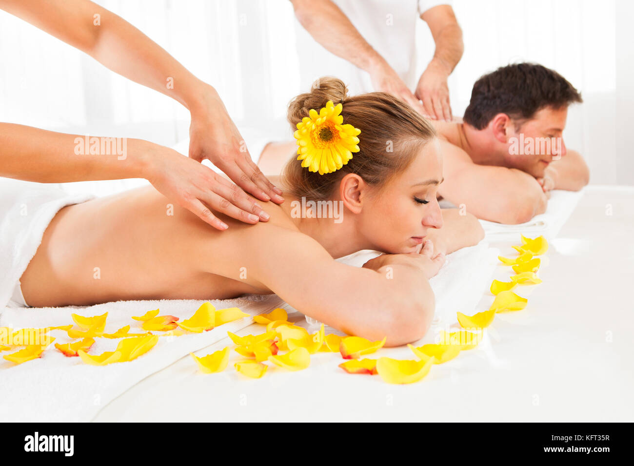 Beau couple couché côte à côte dans un spa offrant le luxe d'un massage en profondeur des tissus ensemble Banque D'Images