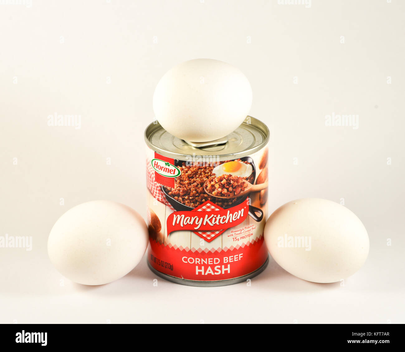 Trois œufs blancs crus frais avec une canette de corned Beef Hash Mary Kitchen prêt à préparer un copieux petit déjeuner. Banque D'Images