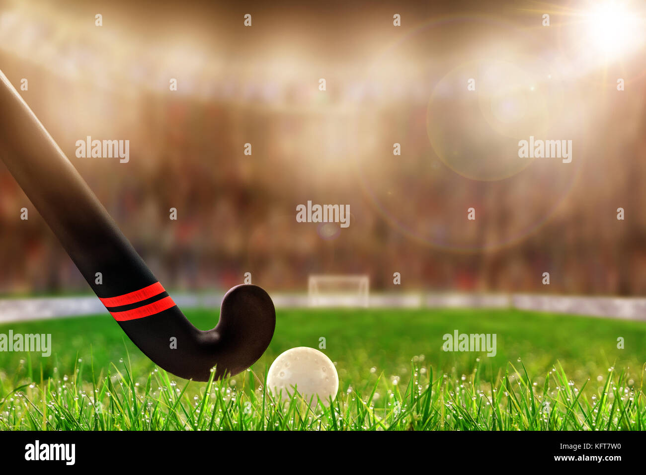 Low angle view of field hockey stick and ball sur terrain herbe et délibérée, faible profondeur de champ sur l'arrière-plan du stade bien éclairé avec copie espace. Banque D'Images