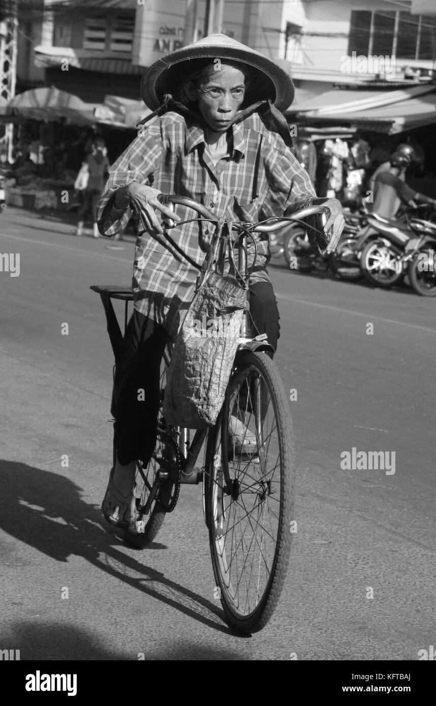 Femme âgée cycliste dans les rues de Hanoi, Vietnam Banque D'Images
