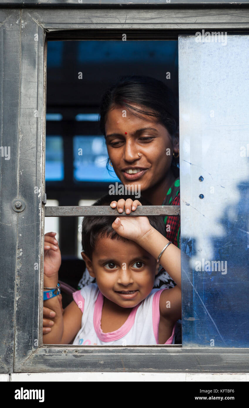 Femme et enfant de la fenêtre de bus à Cooch Behar, Bengale-Occidental, Inde Banque D'Images