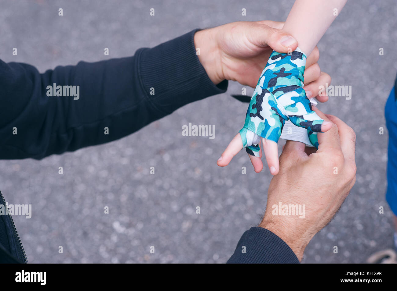 Un jeune entraîneur de boxe de liage à bandages un enfant. l'élève de boxe pour enfants. arrière-plan flou. horizontale. Banque D'Images