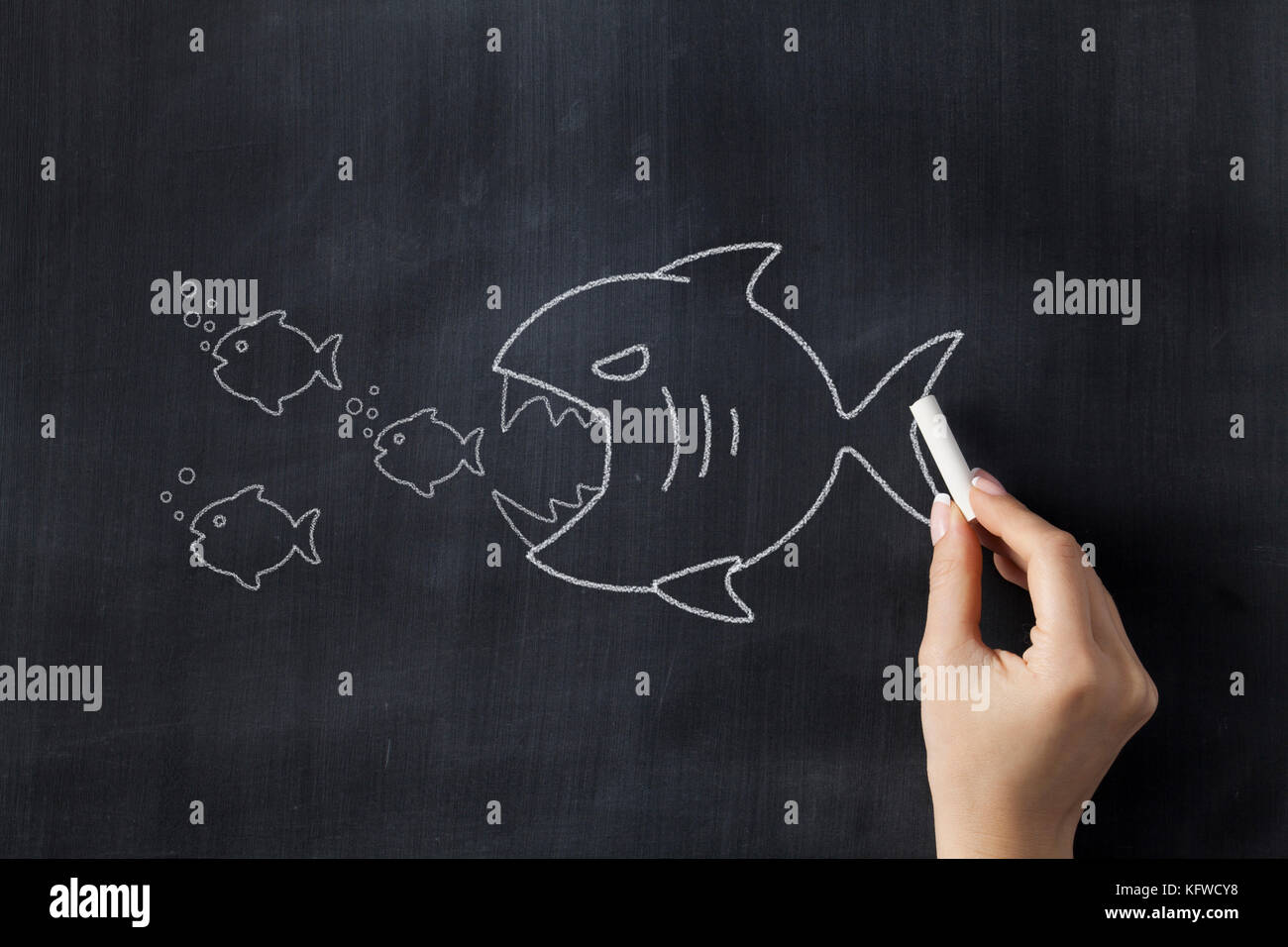 Gros poisson mange groupe de petits poissons. dessin sur tableau noir Banque D'Images