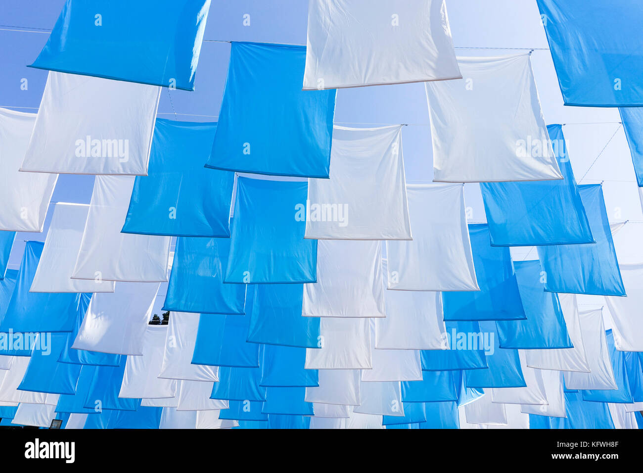 Grand bleu blanc coloré de guirlandes, bannières, décoration, pendant la célébration contre un ciel bleu ensoleillé. Banque D'Images