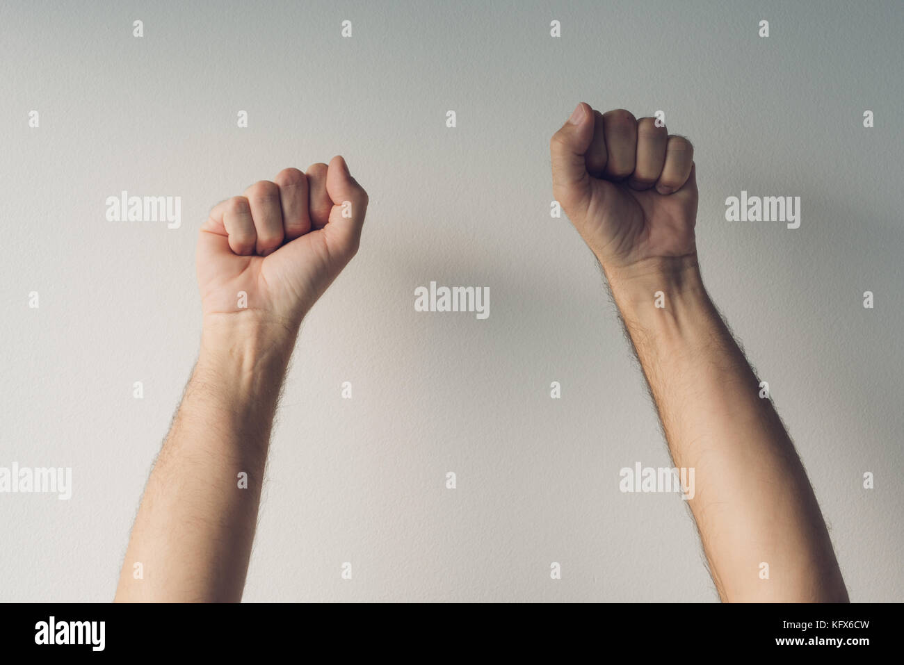 Les poings serrés et bras levés en manière victorieuse, homme, mains en l'air comme symbole de victoire et de réussite Banque D'Images