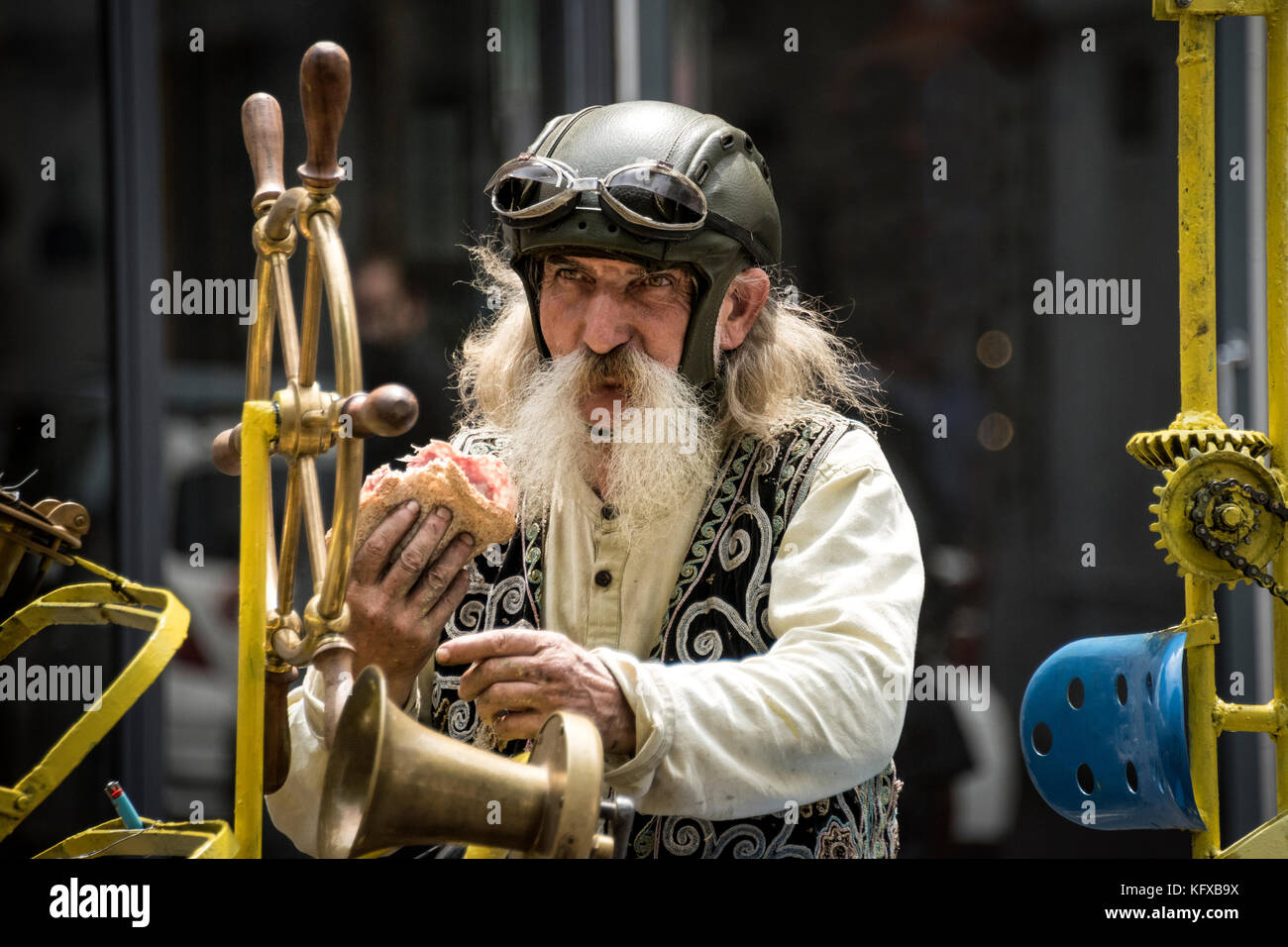 Homme parisien sur son vélo de voyage dans le temps steampunk mangeant un sandwich, Paris Banque D'Images