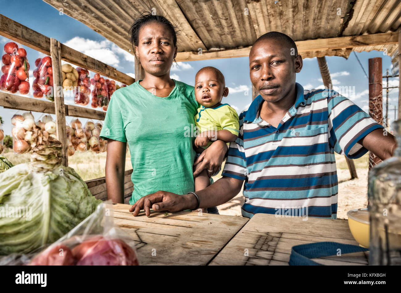 La famille africaine debout dans une boutique de bord de route Banque D'Images