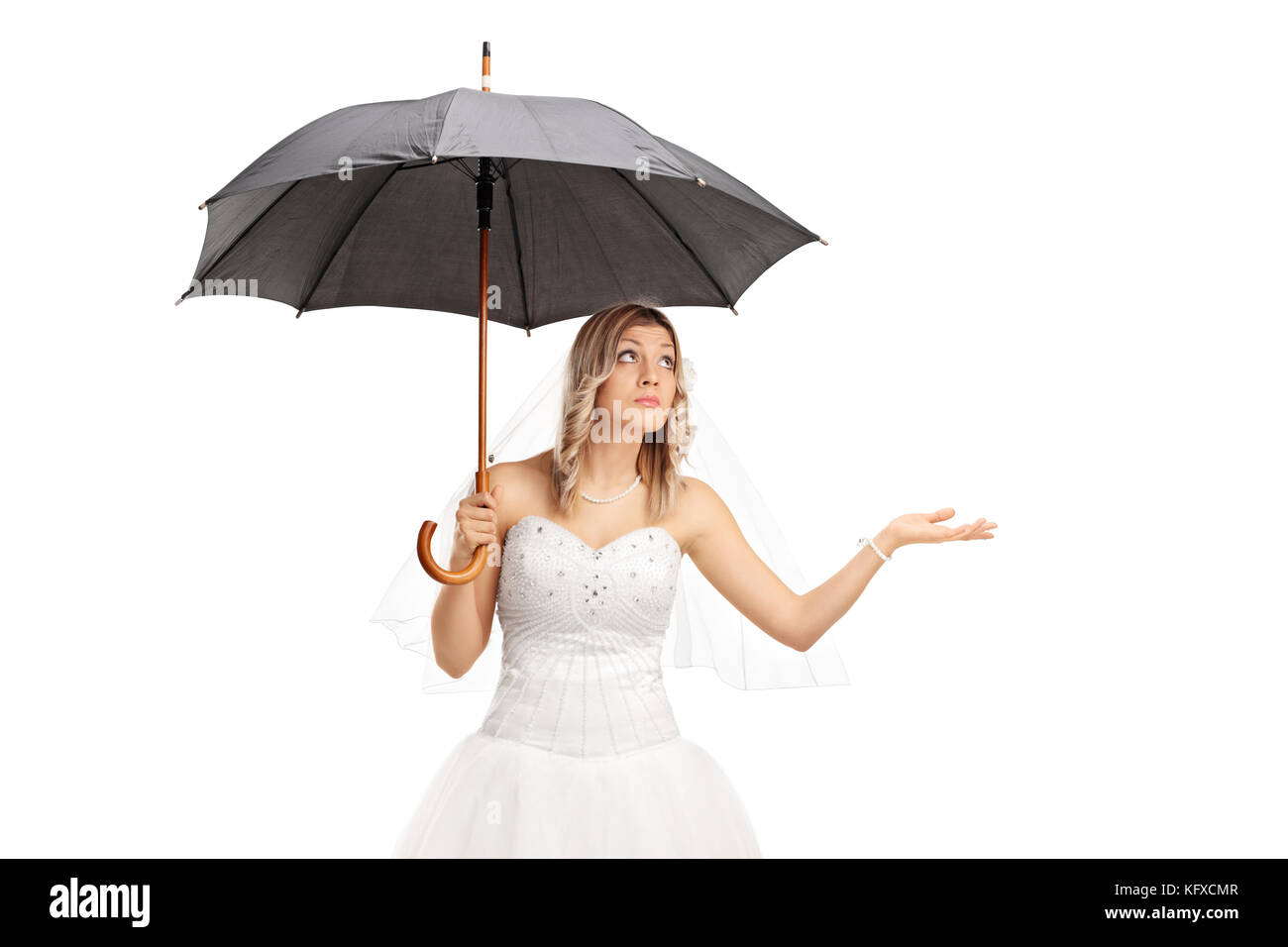 Jeune mariée dans une robe de mariée blanche tenant un parapluie isolé sur fond blanc Banque D'Images