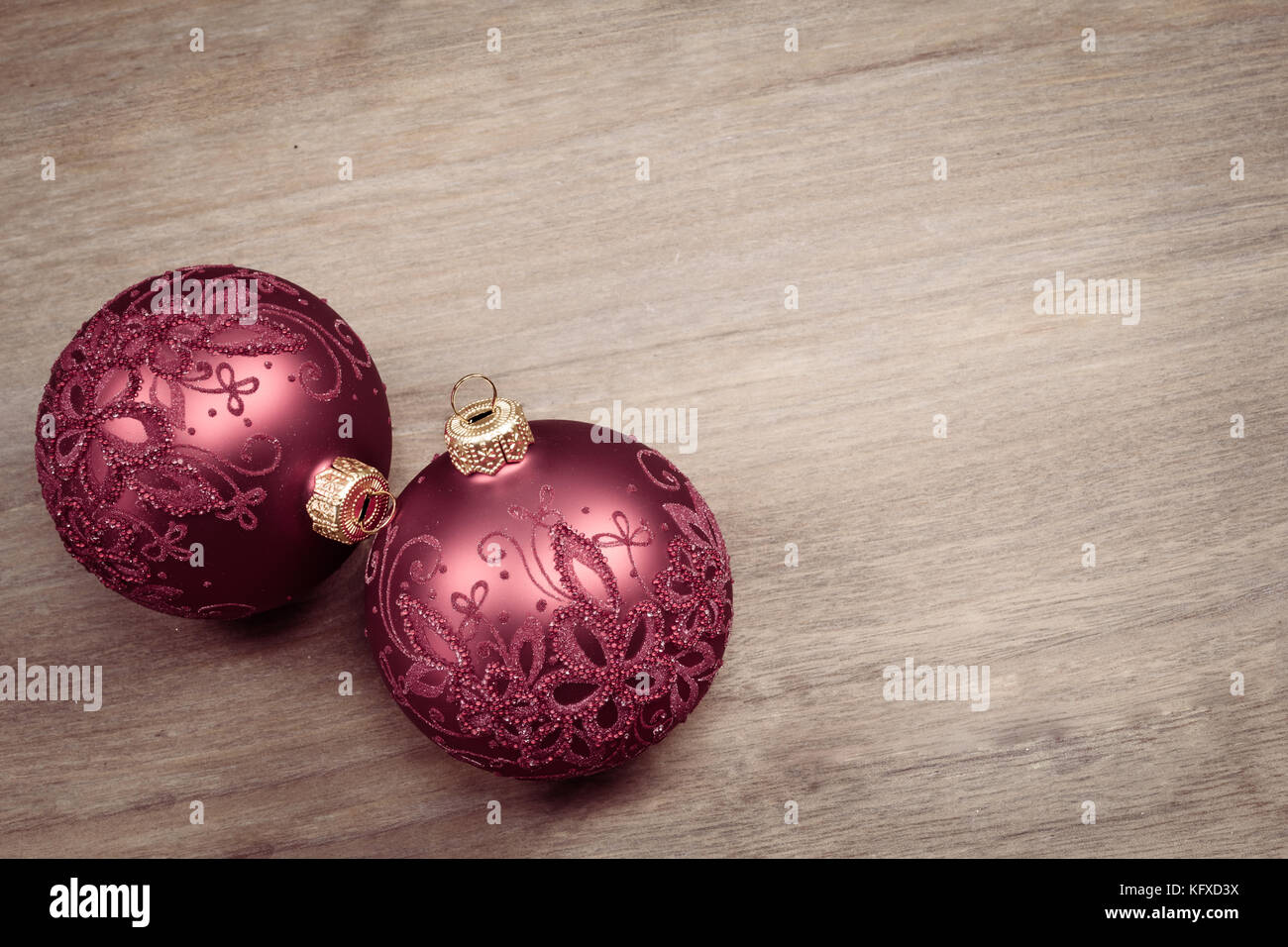 Deux boules de Noël isolées sur fond de bois. Boules en verre décorées. Banque D'Images