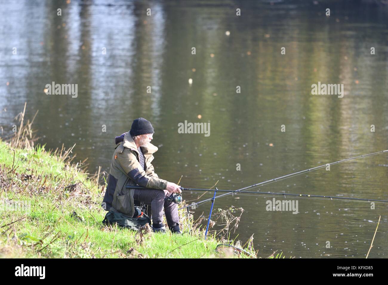 Un homme pêche dans la rivière Mersey, heaton mersey, Stockport, Greater Manchester.. il y a plusieurs décennies la rivière était si sale que le poisson ne pourrait pas survivre. Banque D'Images