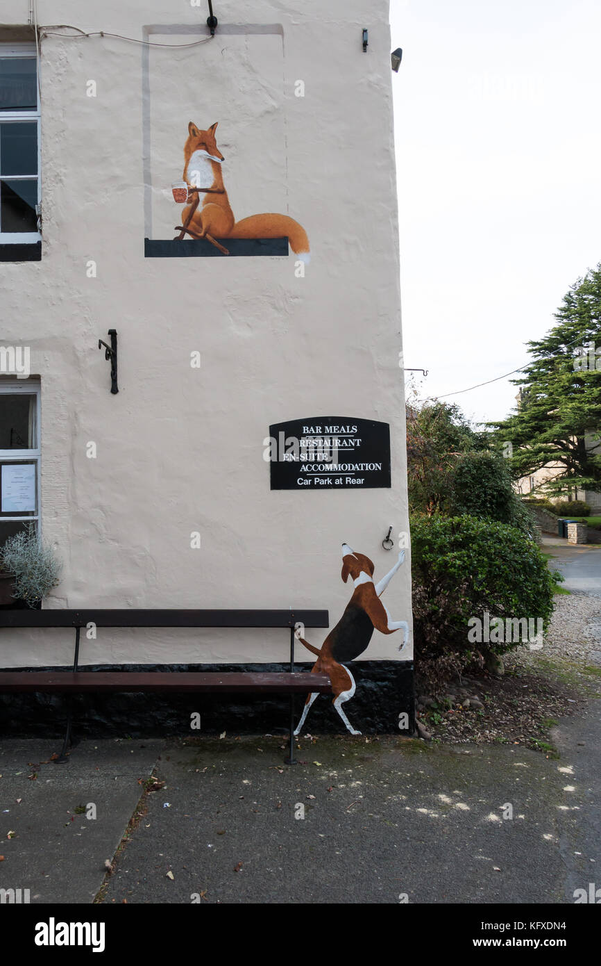 Des œuvres d'un chien et un renard de boire une pinte de bière sur le mur extérieur de la Fox and Hounds pub dans Cotherstone Teesdale, UK, Banque D'Images