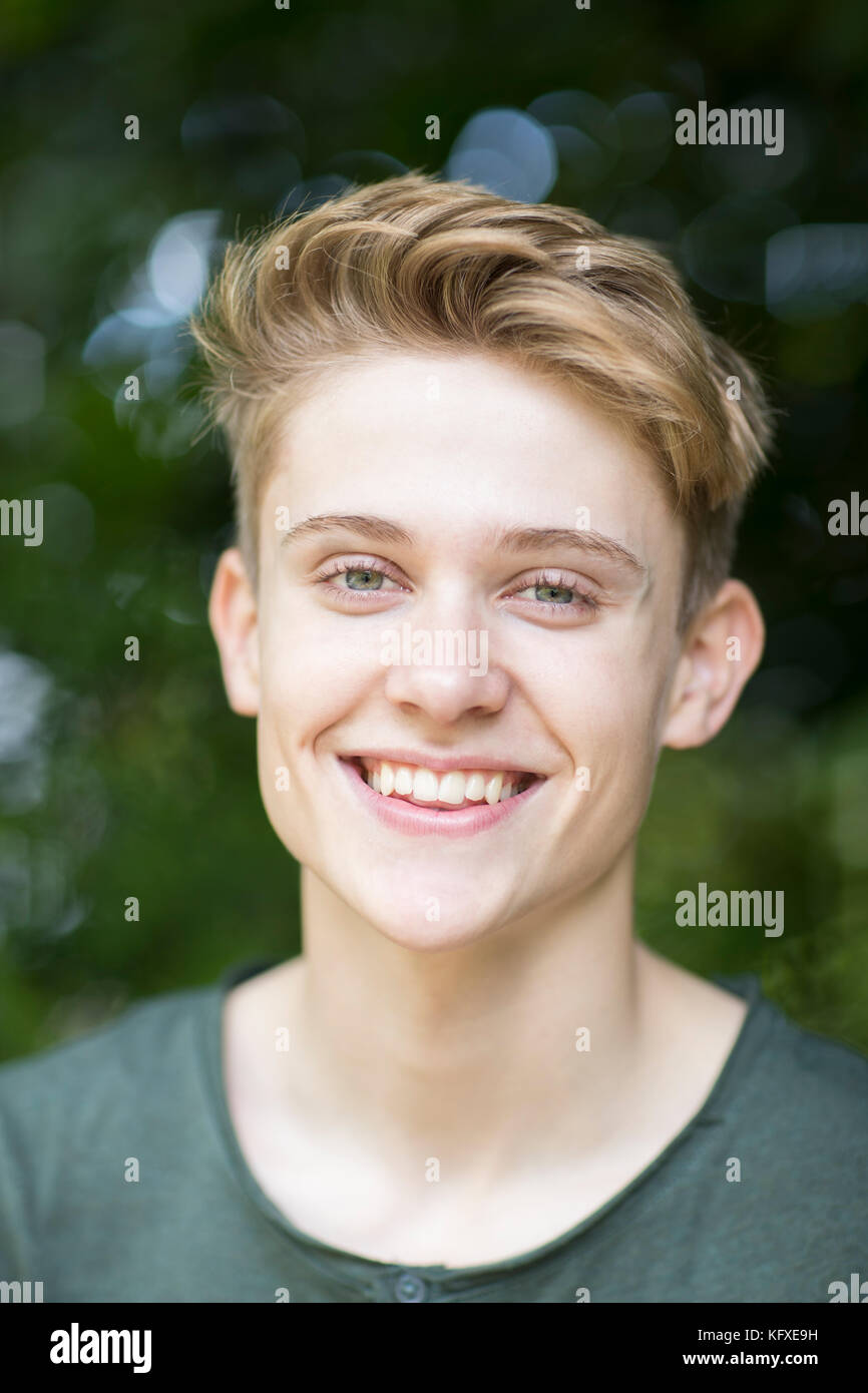 Portrait of happy Young boy sitting outdoors Banque D'Images