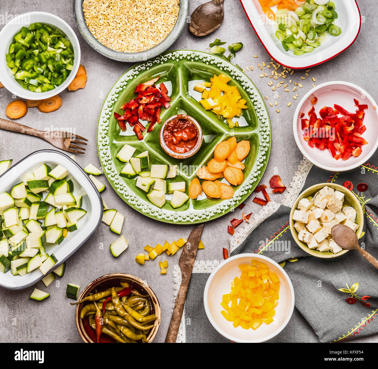 La préparation d'aliments sains : gut légumes colorés sur plaque verte et des bols avec les semences d'orge et de feta salade. ou ragoût ingrédients. Banque D'Images
