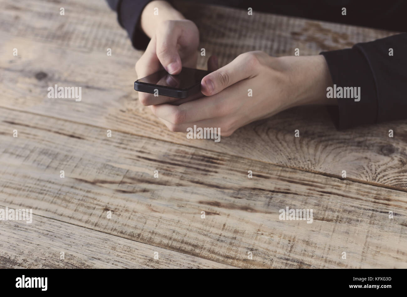 Close up of male hands holding smartphone et doigt de graphique et texte à l'écran à la table des planches. hipster style. espace libre pour le texte. Banque D'Images