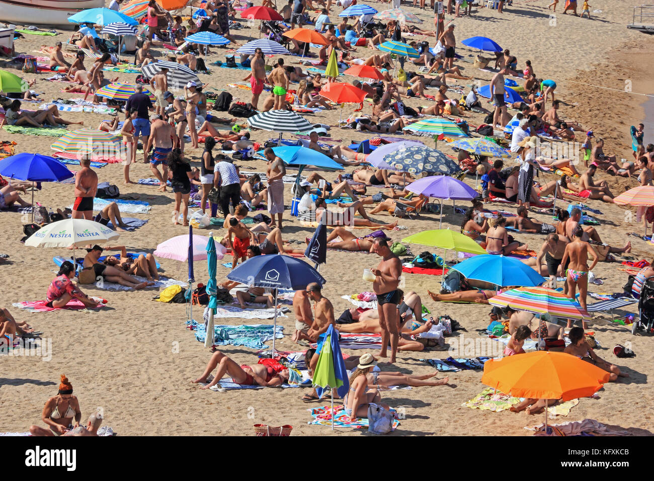 Les vacanciers de soleil sur plage, Tossa de Mar, Espagne Banque D'Images