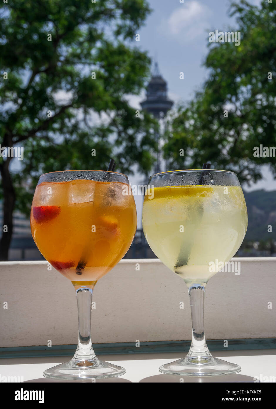 Orange et jaune sangria cocktails sur des verres avec paille. close up sur les boissons alcoolisées à froid avec de la glace, les fraises tranchées à Barcelone. Banque D'Images