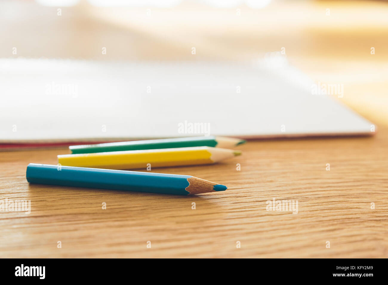Crayons de couleur et blanc ordinateur portable sur une table en bois avec focus sélectif. Banque D'Images