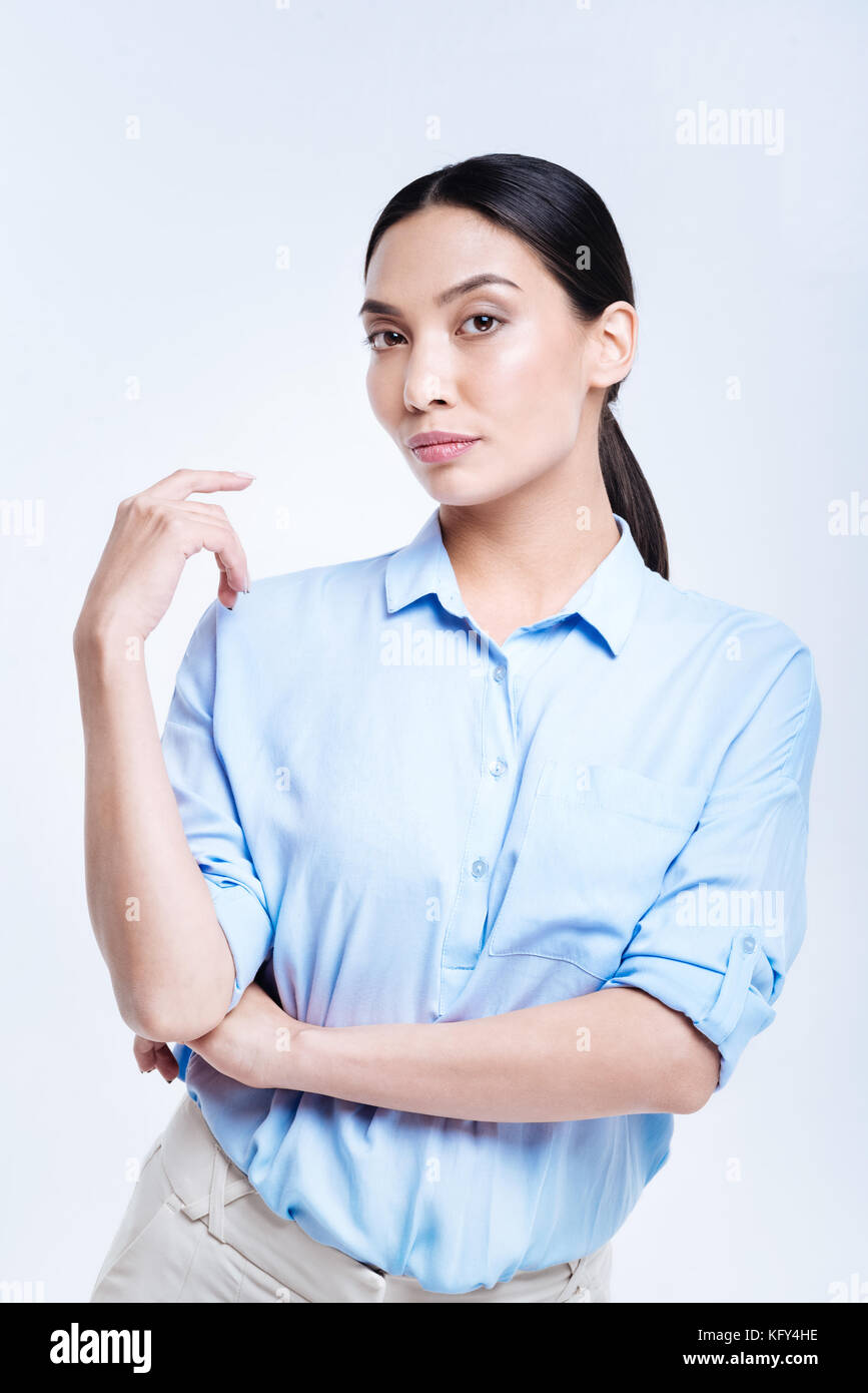 Gorgeous woman in blue shirt posing against white background Banque D'Images