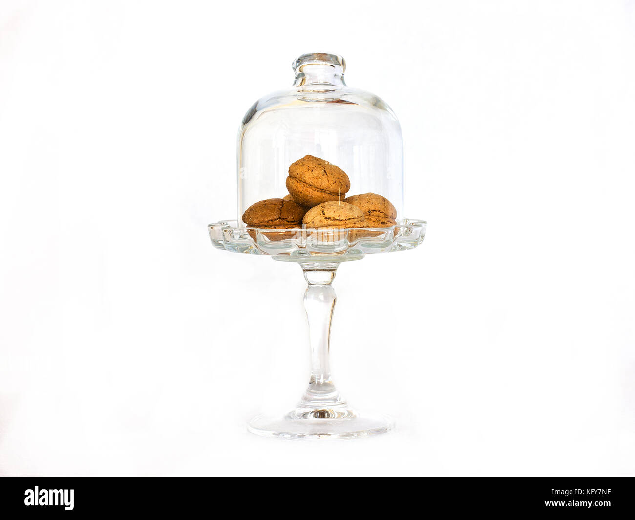 Petits biscuits aux amandes dans un vase en verre sur une jambe sous le bouchon de verre isolé. Banque D'Images