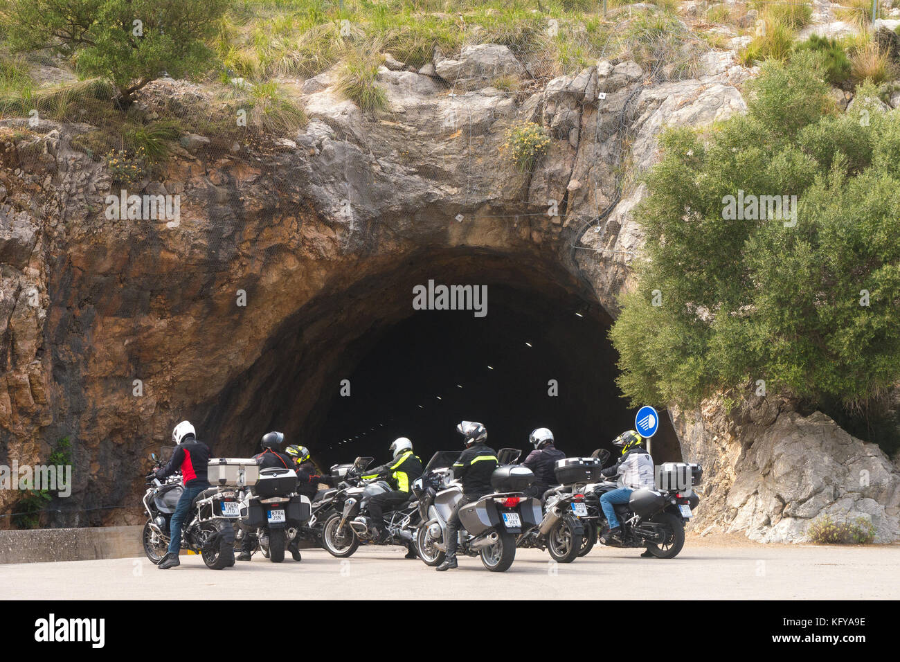 Un groupe de passionnés de moto prepare to ride à travers un tunnel dans le flanc d'une montagne à Mallorca, Espagne. Banque D'Images