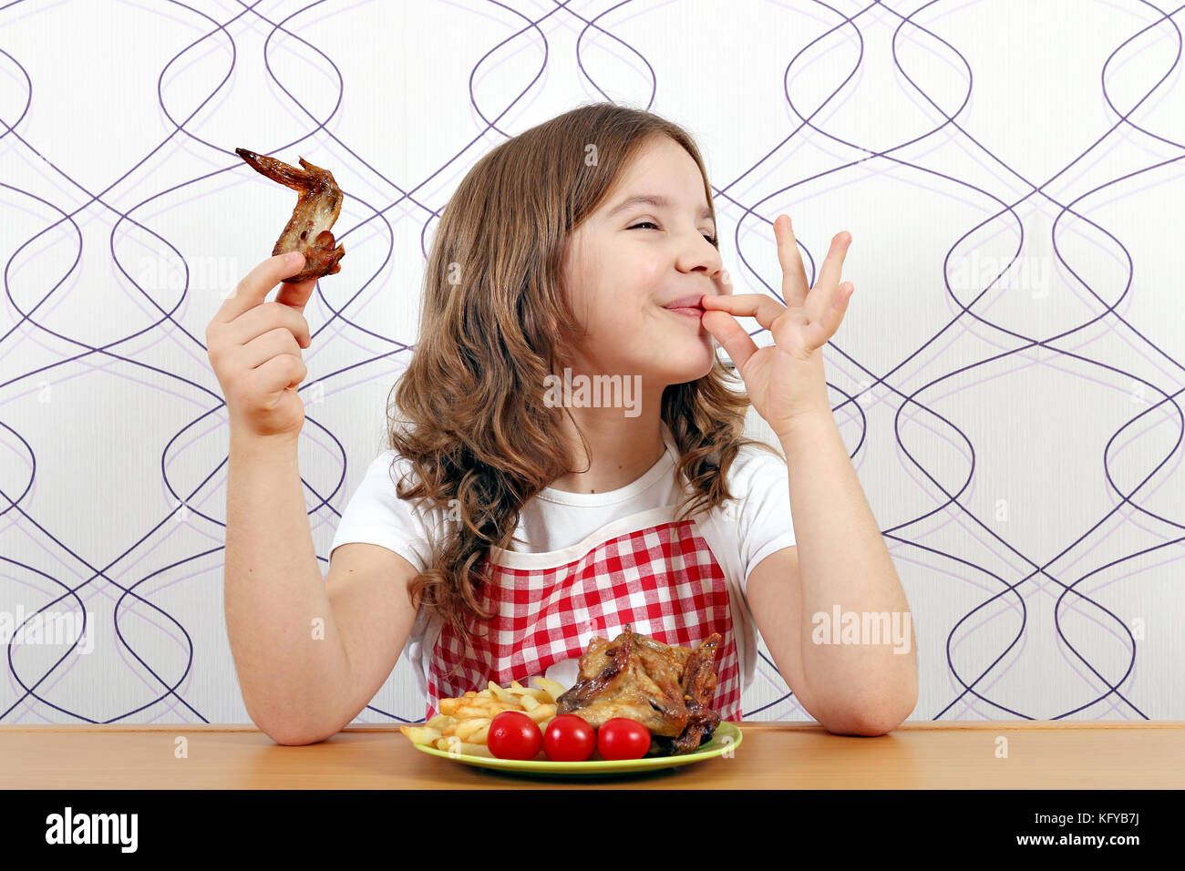 Happy little girl avec des ailes de poulet et la main ok sign Banque D'Images
