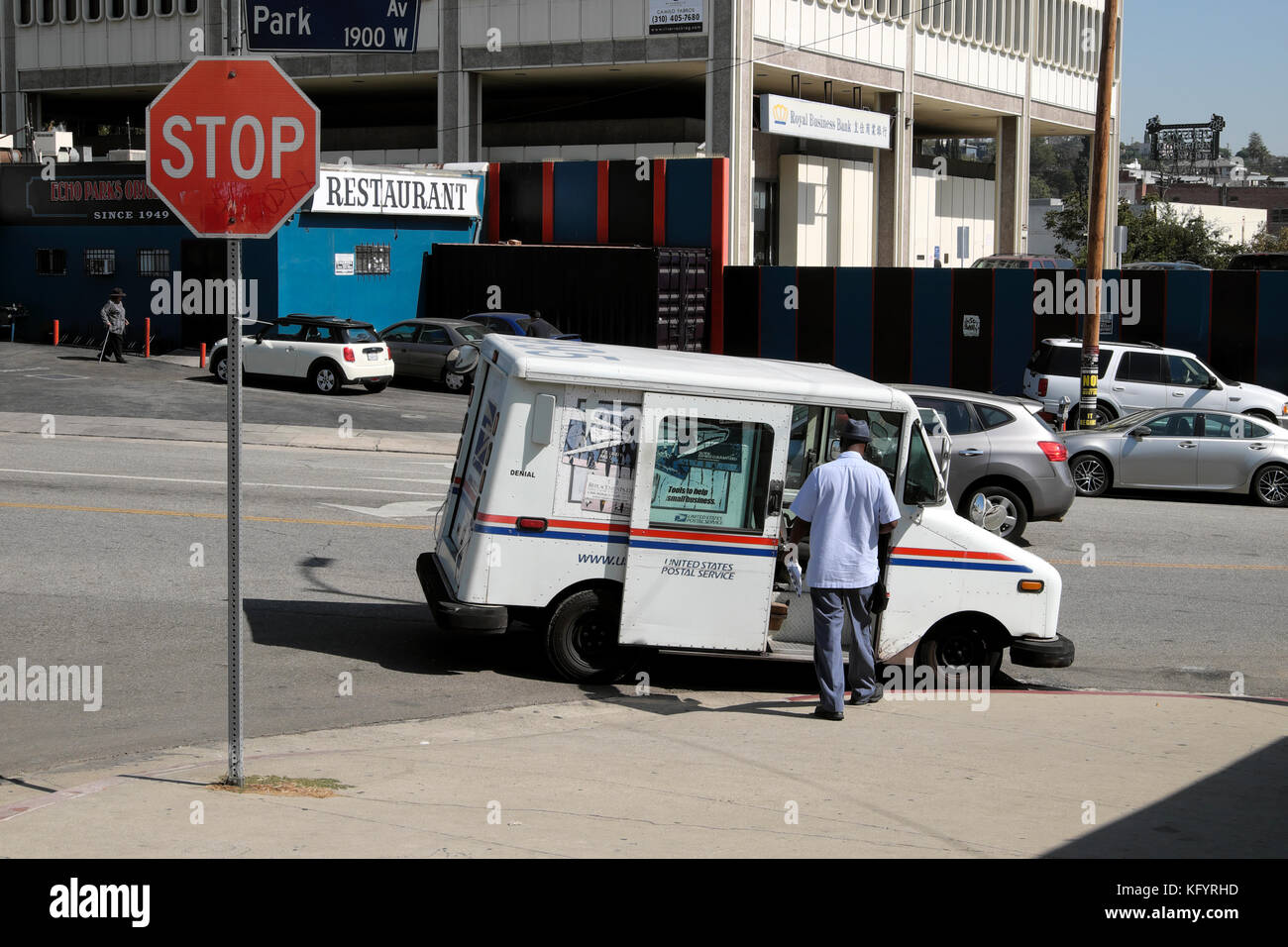 United States Postal van et mailman sur un coin de rue dans Echo Park, Los Angeles, California USA KATHY DEWITT Banque D'Images