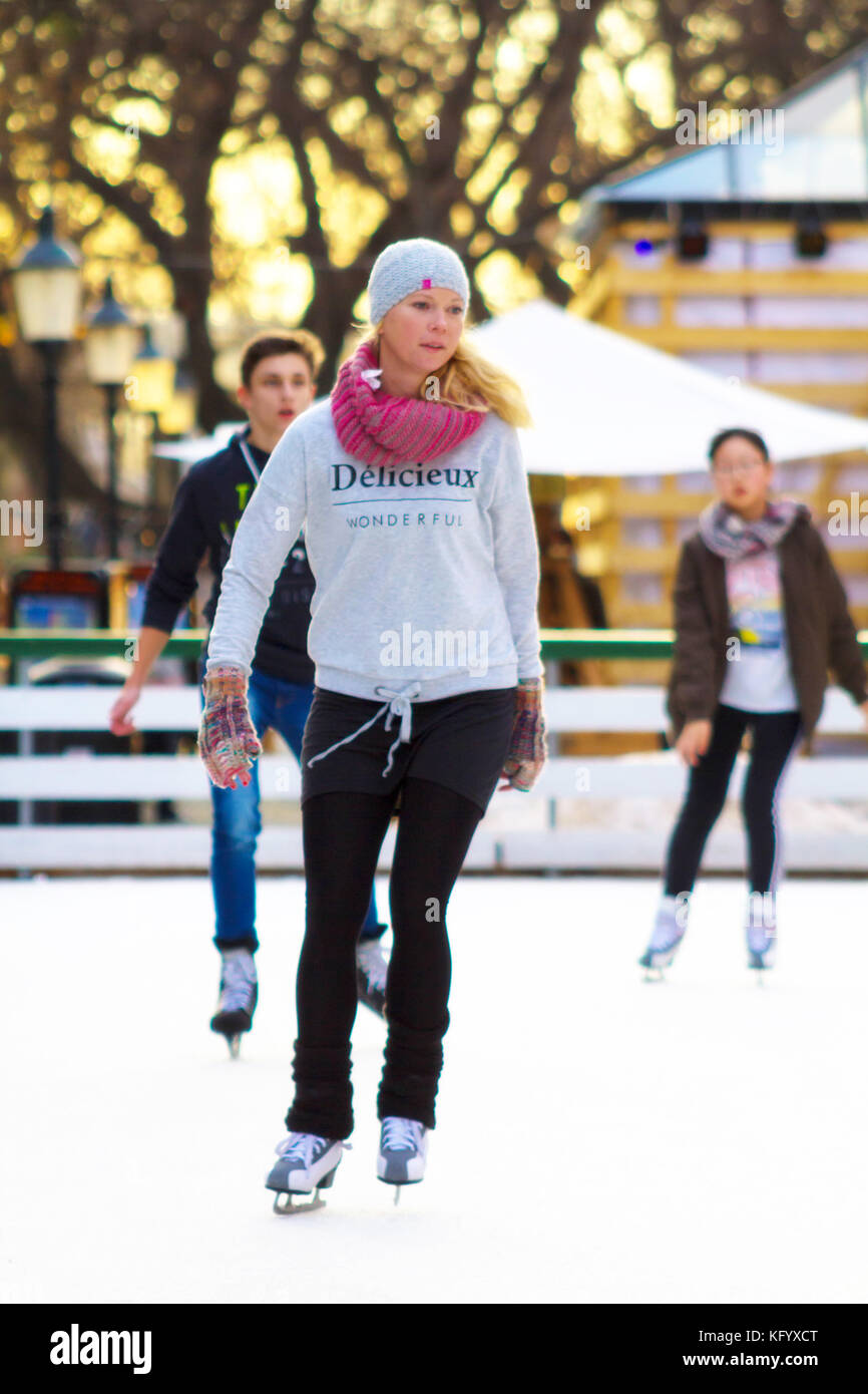 Une jeune femme patinage sur une patinoire en plein air. Banque D'Images