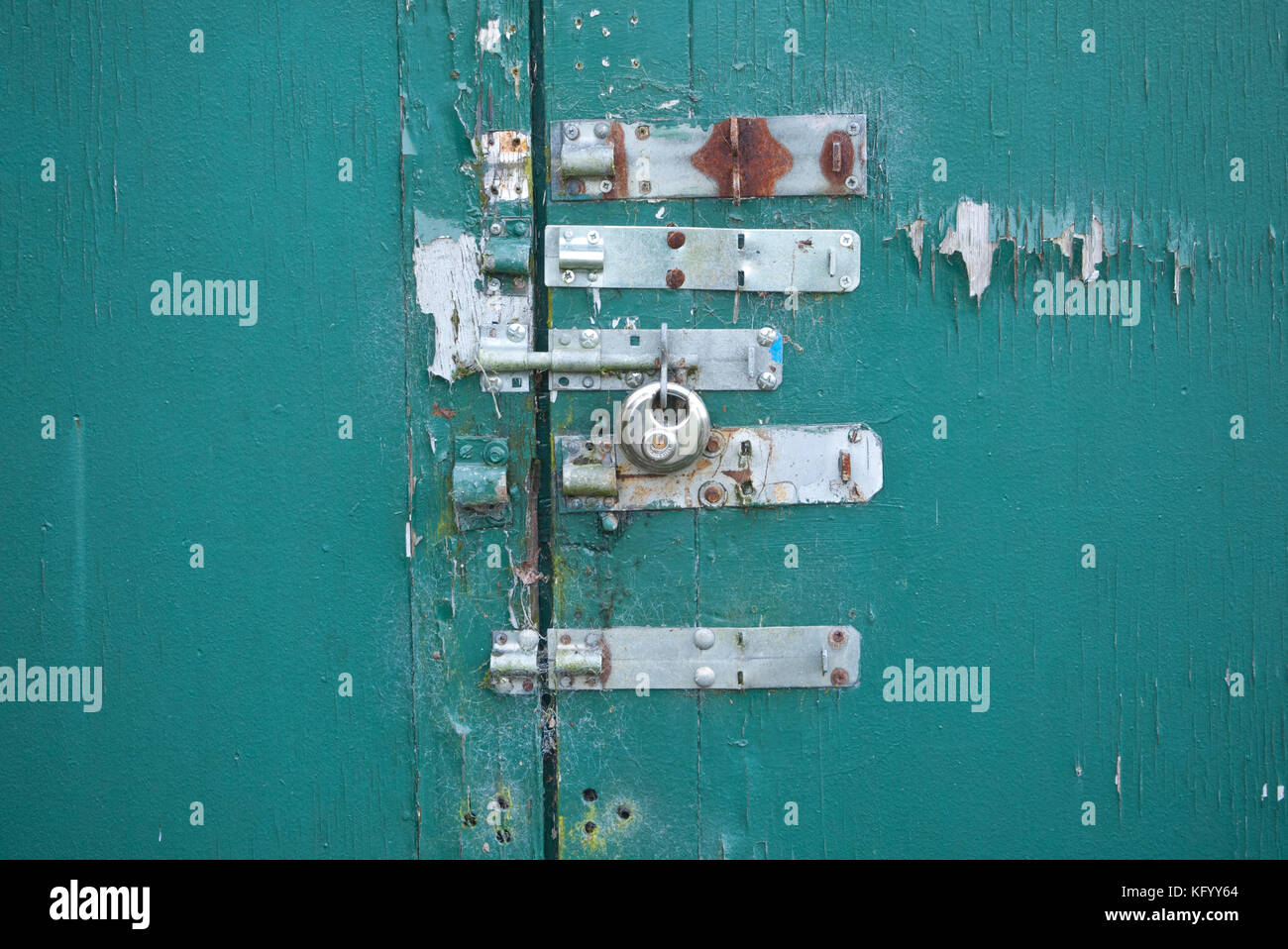 Ancienne serrure fermoirs sur une ancienne porte de garage, UK. Banque D'Images