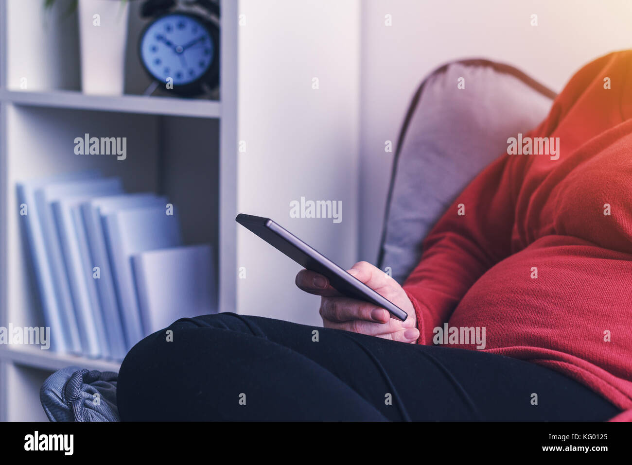 Femme enceinte détendue à l'aide de smart phone app mobile et à s'informer sur la grossesse et la maternité, selective focus Banque D'Images