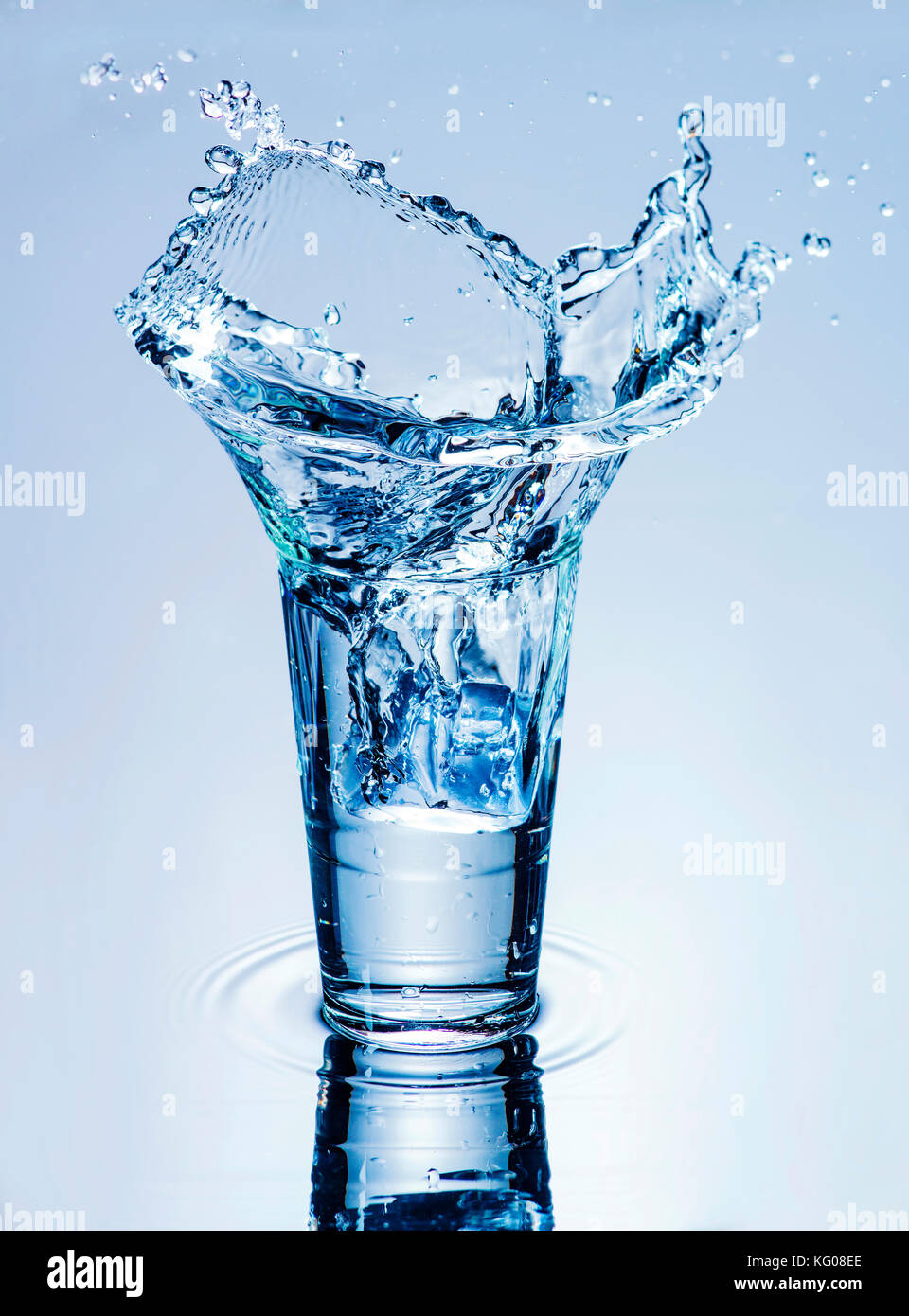 L'icecube projections dans un verre d'eau. Banque D'Images