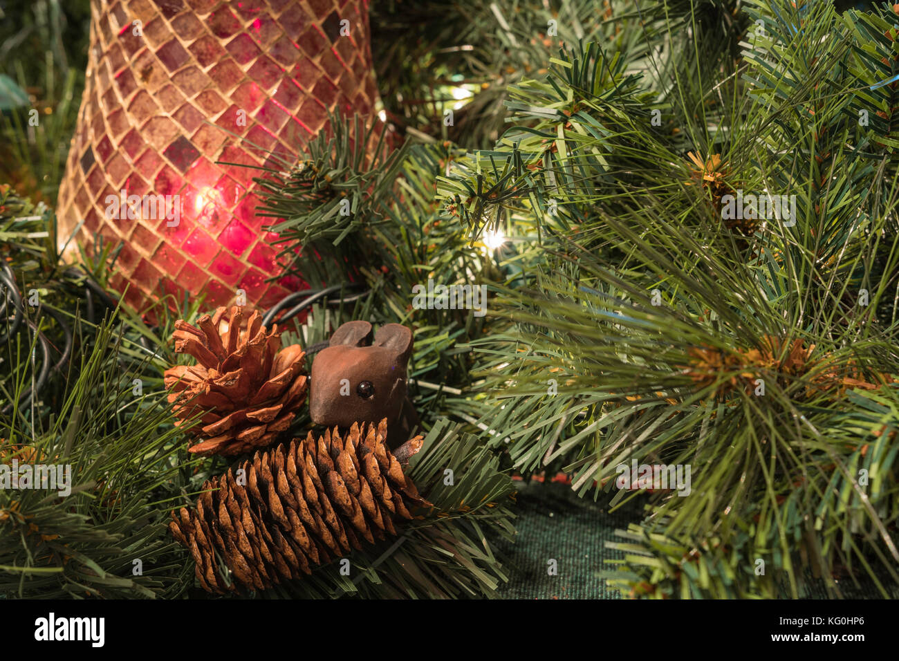 La verdure de Noël rouge avec porte-bougie, pommes de pin et de la souris en bois peu Banque D'Images