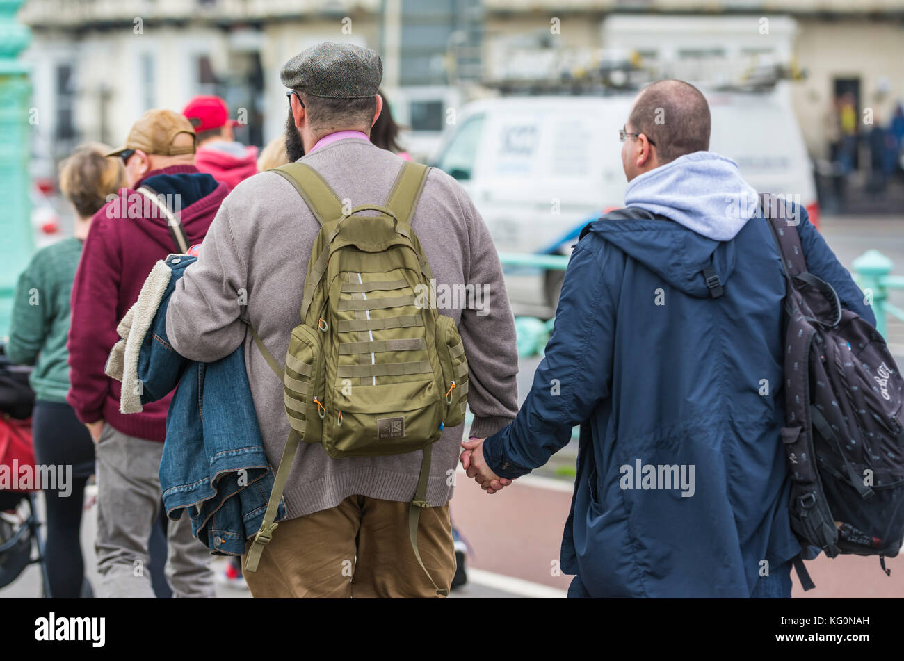 Les hommes âgés moyens de couple holding hands in Brighton, East Sussex, Angleterre, Royaume-Uni. Banque D'Images