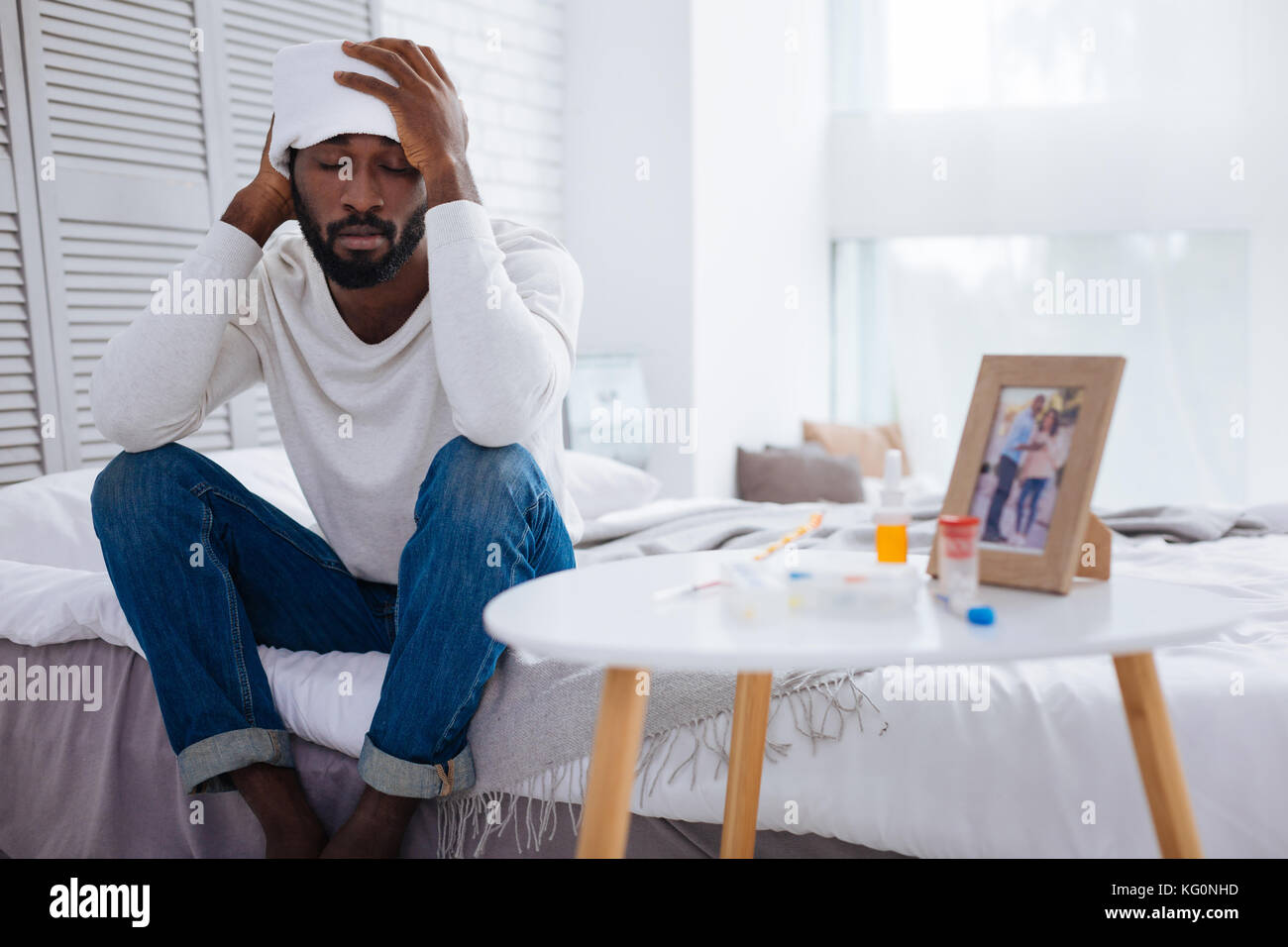 Les jeunes malades homme assis avec ses yeux fermés Banque D'Images