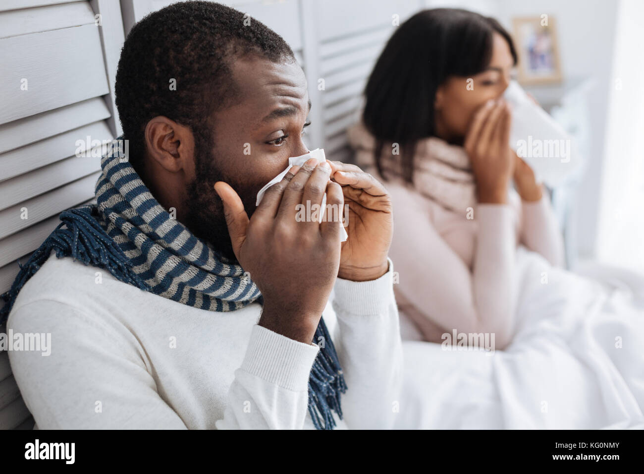 Deux personnes malades alors que les éternuements siégeant ensemble Banque D'Images